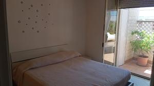 トッレ・デル・オルソにあるAppartamento Gentileの窓付きの部屋にベッド付きのベッドルーム1室があります。