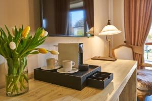 una habitación con una mesa con tazas y un jarrón con flores en Resort Čapí Hnízdo, en Olbramovice