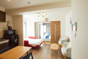 ein Wohnzimmer mit einem Zimmer mit einem Bett und einem Tisch in der Unterkunft SG Premium KASAI in Tokio