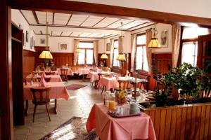 ein Restaurant mit Tischen und Stühlen mit rosa Tischtuch in der Unterkunft Hotel Restaurant Adler Bühlertal in Bühlertal