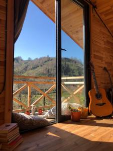 een kamer met een groot raam met een gitaar bij Şana Yaşam Köyü 