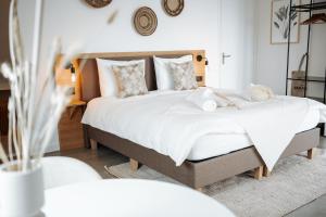 1 Schlafzimmer mit 2 Betten mit weißer Bettwäsche und Kissen in der Unterkunft Hotel Paradis Zandvoort in Zandvoort