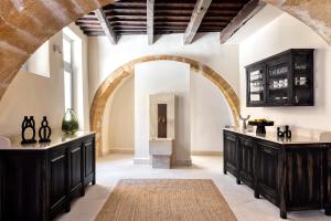 a kitchen with black cabinets and an archway at AZADE Chania in Chania Town