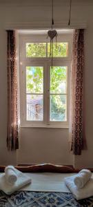 ventana con 2 toallas en una cama en una habitación en Maroudas Traditional Guest House en Vathi