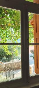 a window with a view of a park seen through it at Maroudas Traditional Guest House in Vathi