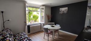 sala de estar con mesa blanca y ventana en Belle dépendance, appartement cosy, tout confort, en Montpellier