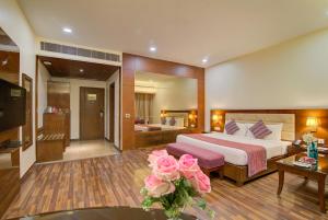 a hotel room with a bed and a living room at Hotel Home In By Amrik Sukhdev in Sonīpat
