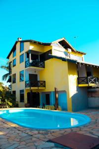 a building with a swimming pool in front of a building at Pousada Villa Guimaraes in Chapada dos Guimarães