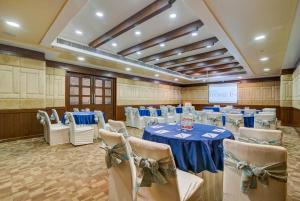 a banquet hall with a blue table and chairs at Hotel Home In By Amrik Sukhdev in Sonīpat