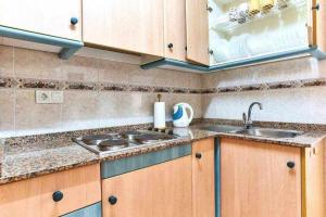 kuchnia z drewnianymi szafkami i zlewem w obiekcie Espanhouse Diego apartment w mieście Torrevieja
