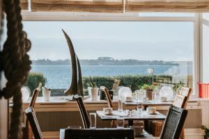 a dining room with a view of the water at Hôtel Aux Tamaris - Vue Mer in Roscoff