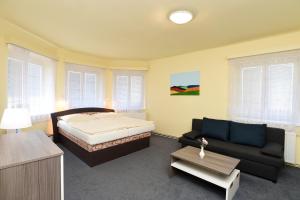 sypialnia z łóżkiem i kanapą w obiekcie Hotel U Jezírka w mieście Liberec