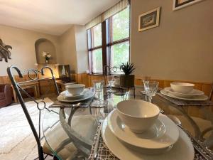 a dining room with a glass table with dishes on it at Pass the Keys Beautiful Apartment - Outstanding Central Location in Dumfries
