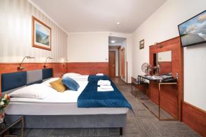 sypialnia z dużym łóżkiem i niebieskim kocem w obiekcie Hotel Rejs we Władysławowie