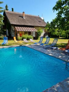 a large swimming pool with chairs and a house at Haus Veronika in Zamárdi