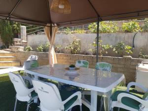 einen Tisch und Stühle unter einem Regenschirm im Hof in der Unterkunft La Casa del Sauce in Archidona