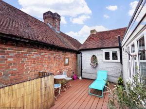 a patio with chairs and a table and a brick building at Robins Rest, Billingshurst in Billingshurst