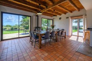 a large dining room with a table and chairs at LA CALYPSO - Magnifique longère avec piscine in Noyalo