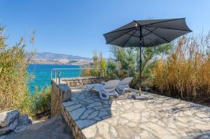 eine Terrasse mit zwei Stühlen und einem Sonnenschirm in der Unterkunft House Branimir in Kolan