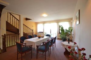 a dining room with a white table and chairs at Dworek Morski in Kołobrzeg