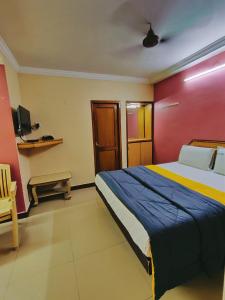 a bedroom with a large bed and a red wall at Hotel DKR Residency in Tirupati