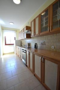a kitchen with wooden cabinets and a tile floor at Dworek Morski in Kołobrzeg +1 photo
