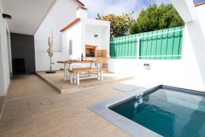 un patio con una mesa y una piscina en Beach Villa Lagoa de Albufeira II, en Lagoa de Albufeira