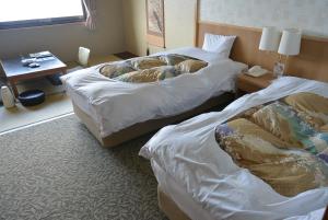 a hotel room with two beds and a table at Toya Kanko Hotel in Lake Toya