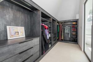 um closet com paredes cinzentas e armários de madeira em Brand new, luxury, 4 bed house, 5 mins to Beach - The Laurels em Poole