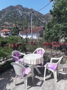 4 sillas y una mesa con sillas púrpuras y una montaña en Apartman Čerkez en Stolac