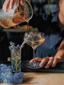 une personne déversant une boisson dans un verre de vin dans l'établissement Hyatt Regency Sofia, à Sofia