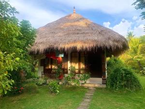 毛梅雷Budi Sun Resort, Flores, Maumere的茅草屋顶的小小屋