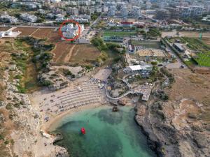 an aerial view of a beach with a red circle at Le casette in Monopoli