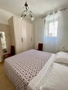 - une chambre avec un lit blanc et une fenêtre dans l'établissement Casa Vacanza di Iside, à Montegiordano