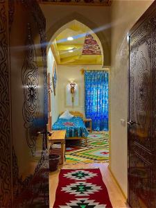 um quarto com uma cama e uma porta com um tapete em Zukhro Boutique Hotel em Khiva