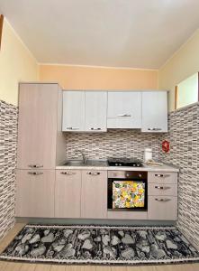 La cuisine est équipée de placards blancs et d'un four. dans l'établissement Casa Vacanza di Iside, à Montegiordano