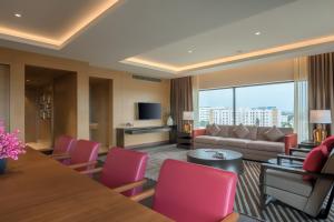 a living room with a couch and a table and chairs at Feathers- A Radha Hotel, Chennai in Chennai