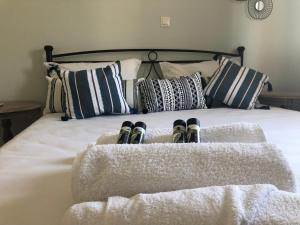 a bed with a bunch of pillows and shoes on it at Pearl kokkonaki in Kokóni