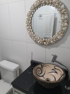 Un baño con un lavabo y un espejo en la pared. en Jequiti-Mar Apto aconchegante na Enseada, en Guarujá 25 fotos más