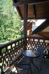 a patio with two chairs and a table on a balcony at Apartament Zacisze in Jaworki