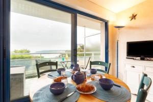 a dining room table with a view of the ocean at Le Valet in Saint-Cast-le-Guildo