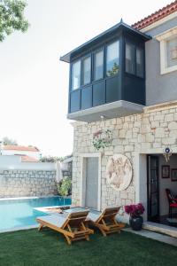 a house with a swimming pool and two lounge chairs at Chloe hotel Alacati in Alacati