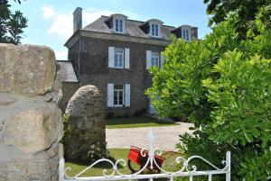 an old stone house with a gate in front of it at Ker Liviou in Lancieux