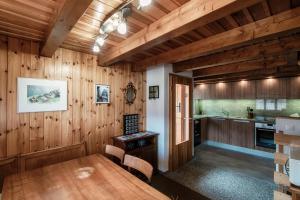 comedor con paneles de madera y mesa en Baita dal Gat by Quokka 360 - modern wooden chalet in Faido, en Sobrio