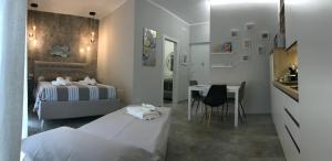 um quarto com uma cama, uma mesa e uma cozinha em Suite107 em Bari