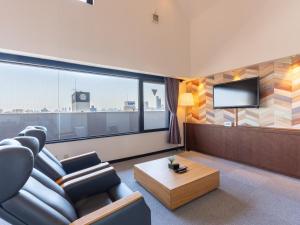 ein Wohnzimmer mit einem Sofa und einem TV in der Unterkunft Tabist Urban Stays Asakusa in Tokio