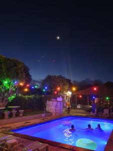 un grupo de personas en una piscina por la noche en Bonito HI Hostel e Pousada, en Bonito