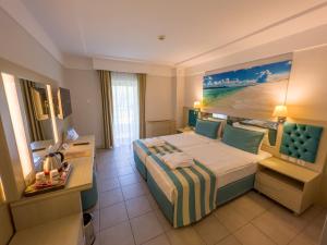 a hotel room with a large bed and a desk at AQI Hydros Club in Kemer +37 photos