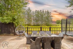 a patio with a table and chairs and a fence at Dorney Barn, Close To Windsor Legoland in Dorney