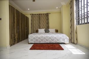 ein Schlafzimmer mit einem großen Bett und einem großen Fenster in der Unterkunft Executive 3-Bed Furnished Apartment in Kwashieman in Accra
